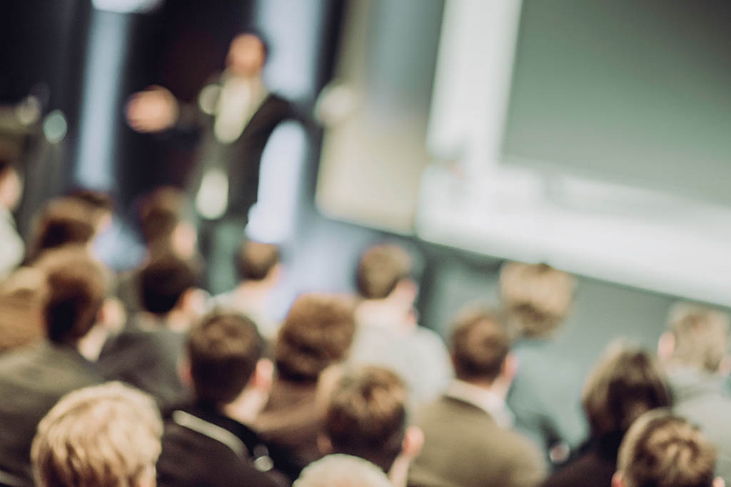 Large Group of People Listening to a Presentation